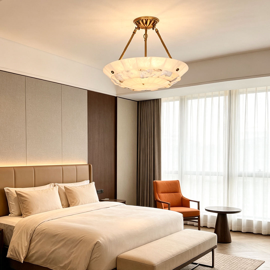 Auréline modern chandelier lit, warm diffused glow from alabaster shade in living room interior