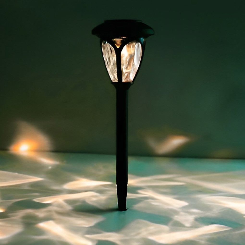 Two Solvara solar path lights staked into grass alongside a garden walkway