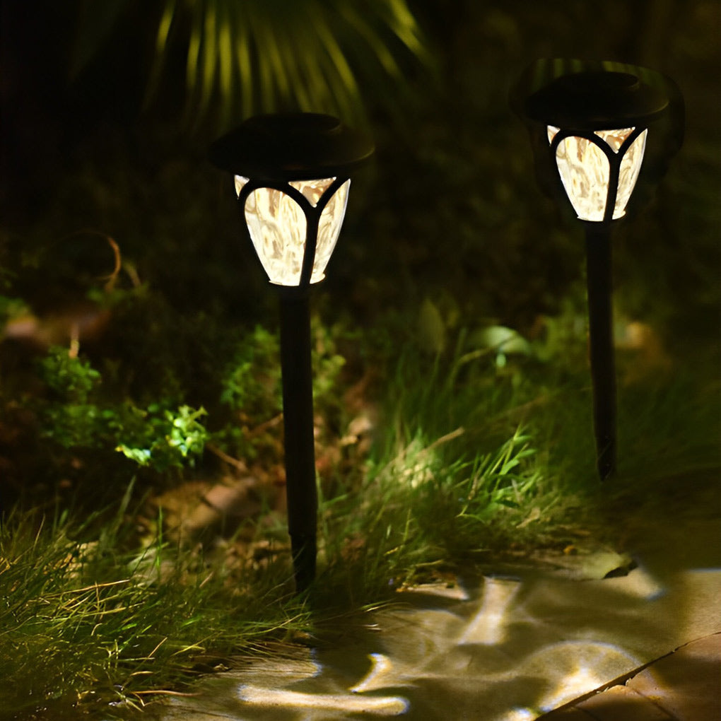 Solvara outdoor stake lights illuminated at dusk showing dusk-to-dawn sensor glow on a patio