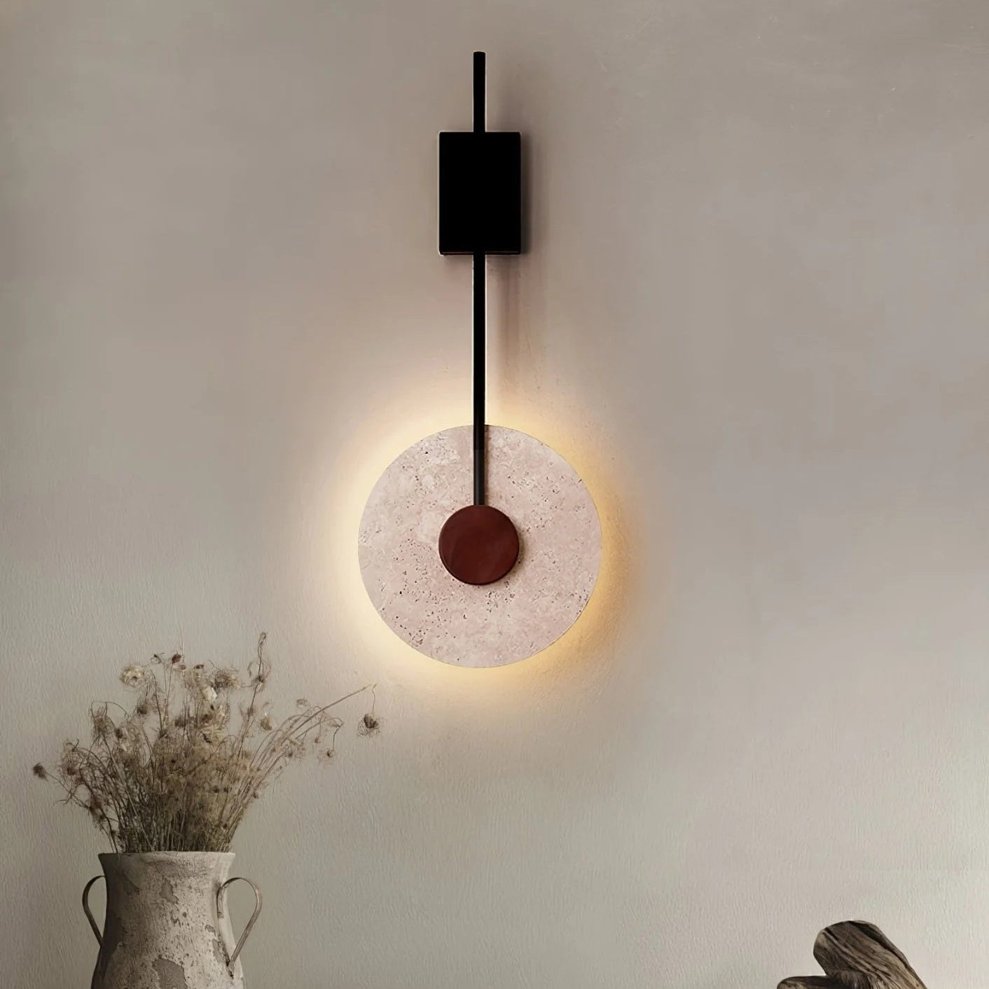 Tovi disc wall light against a white plastered wall in a minimal bedroom