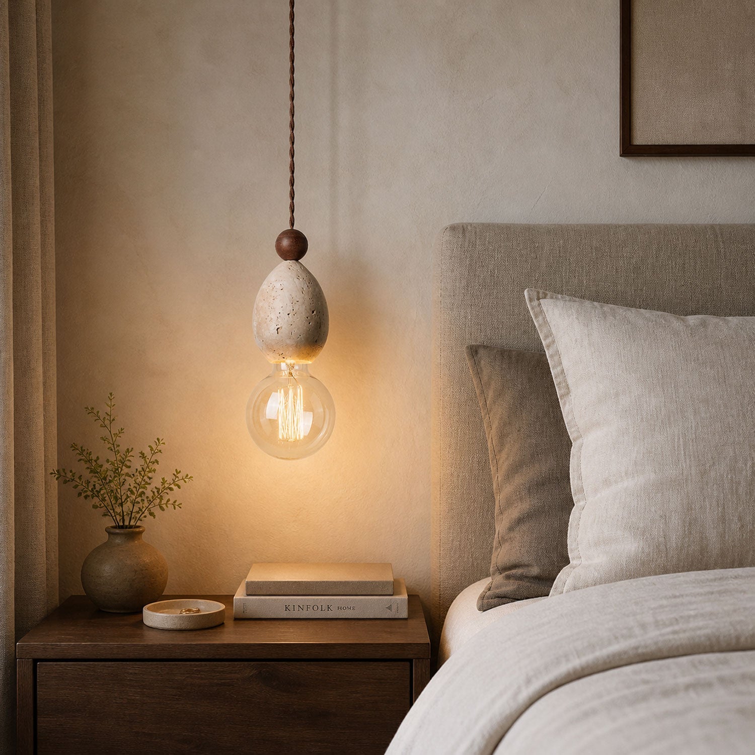 Yellow travertine stone pendant light glowing with warm Edison filament bulb in a calm bedroom setting