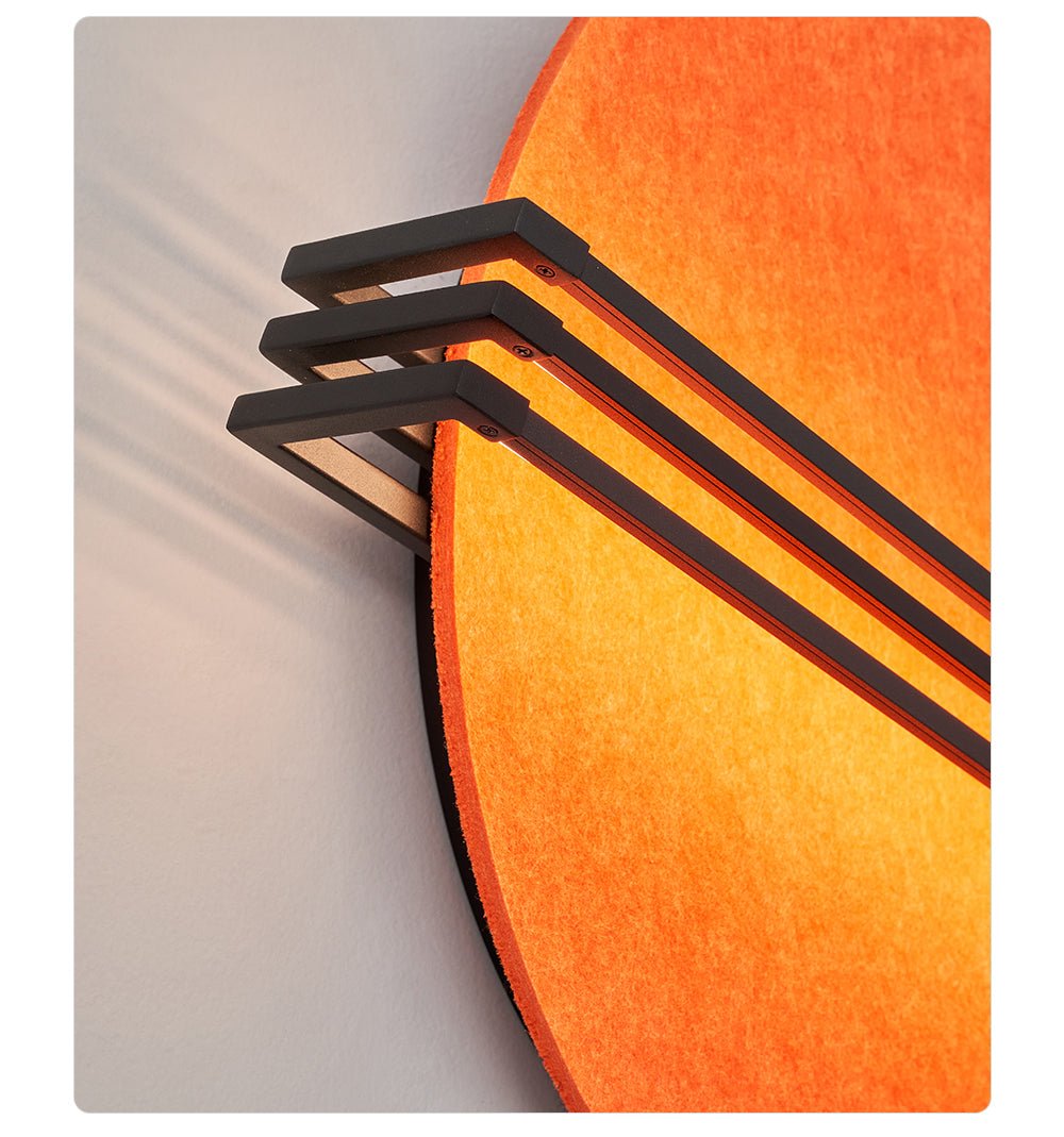 Vantara orange felt wall light illuminated at dusk, creating a warm focal point in a living room