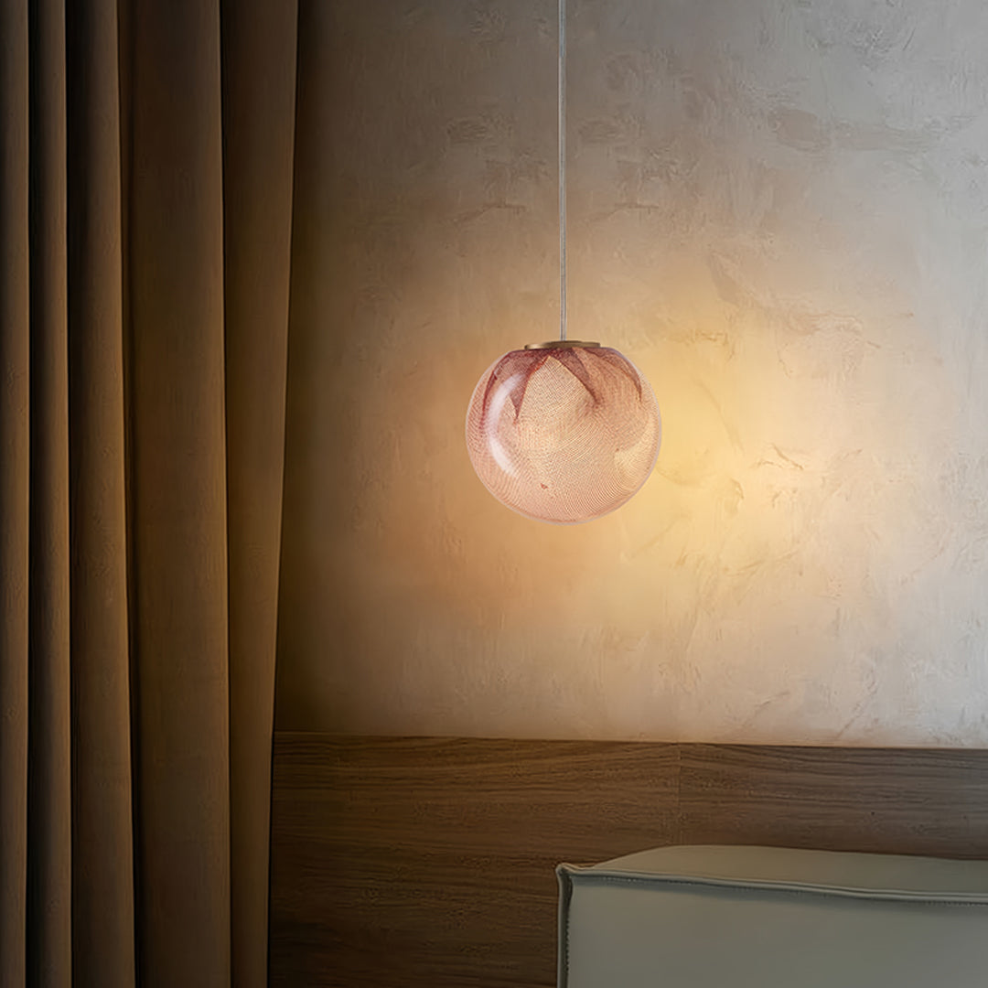 Amber glass sphere pendant light with warm glow in a minimalist setting
