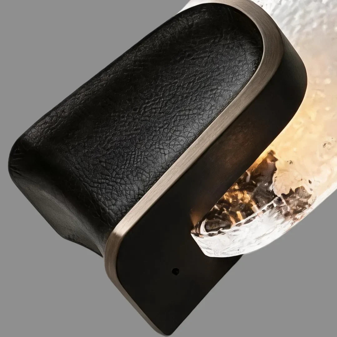 Close-up of black brass and textured glass wall sconce, modern art deco wall light detail