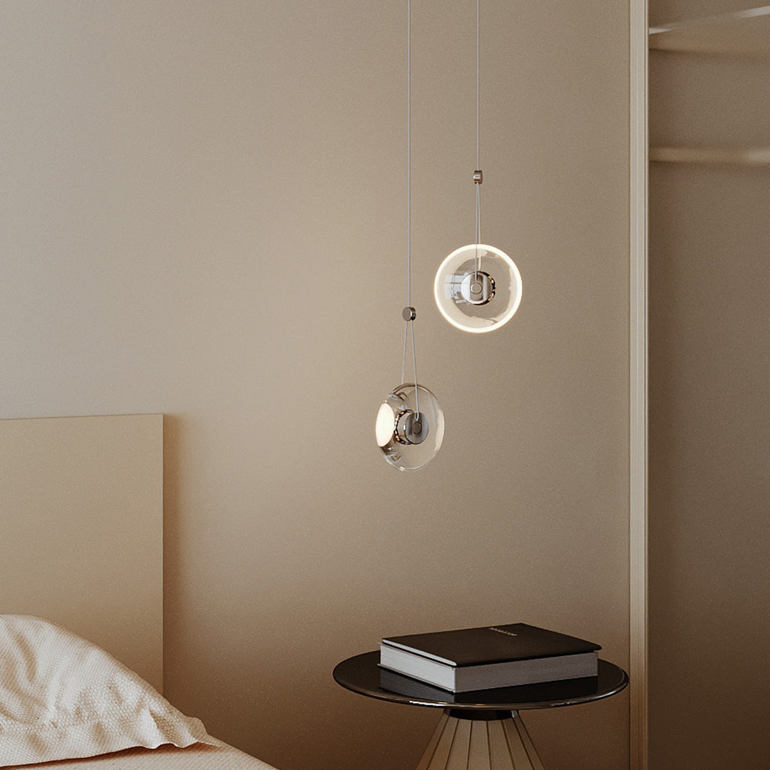 Aureon clear crystal pendant light above a bedside pair in a modern bedroom interior