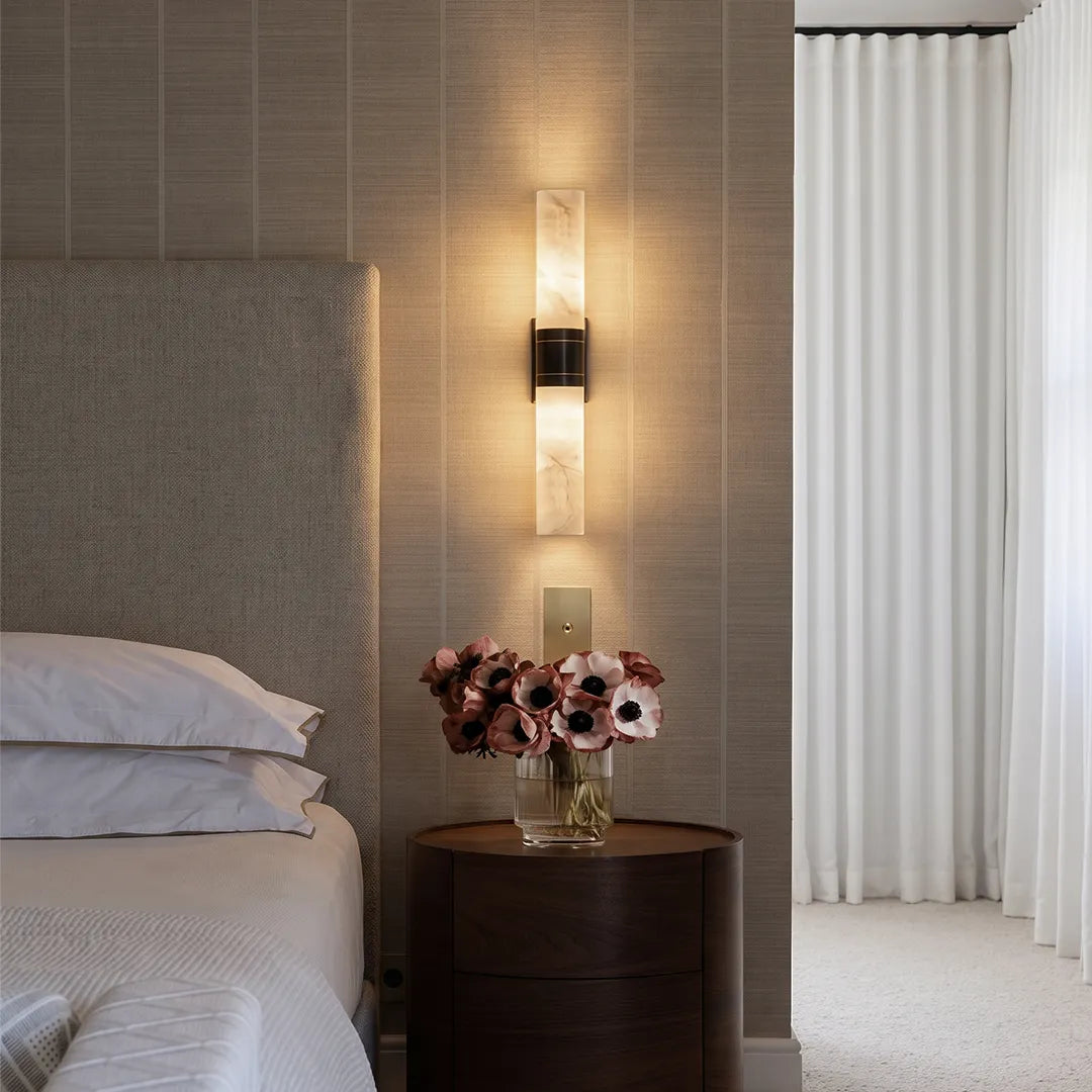 Niva marble wall sconce installed beside a bed as a bedside reading light