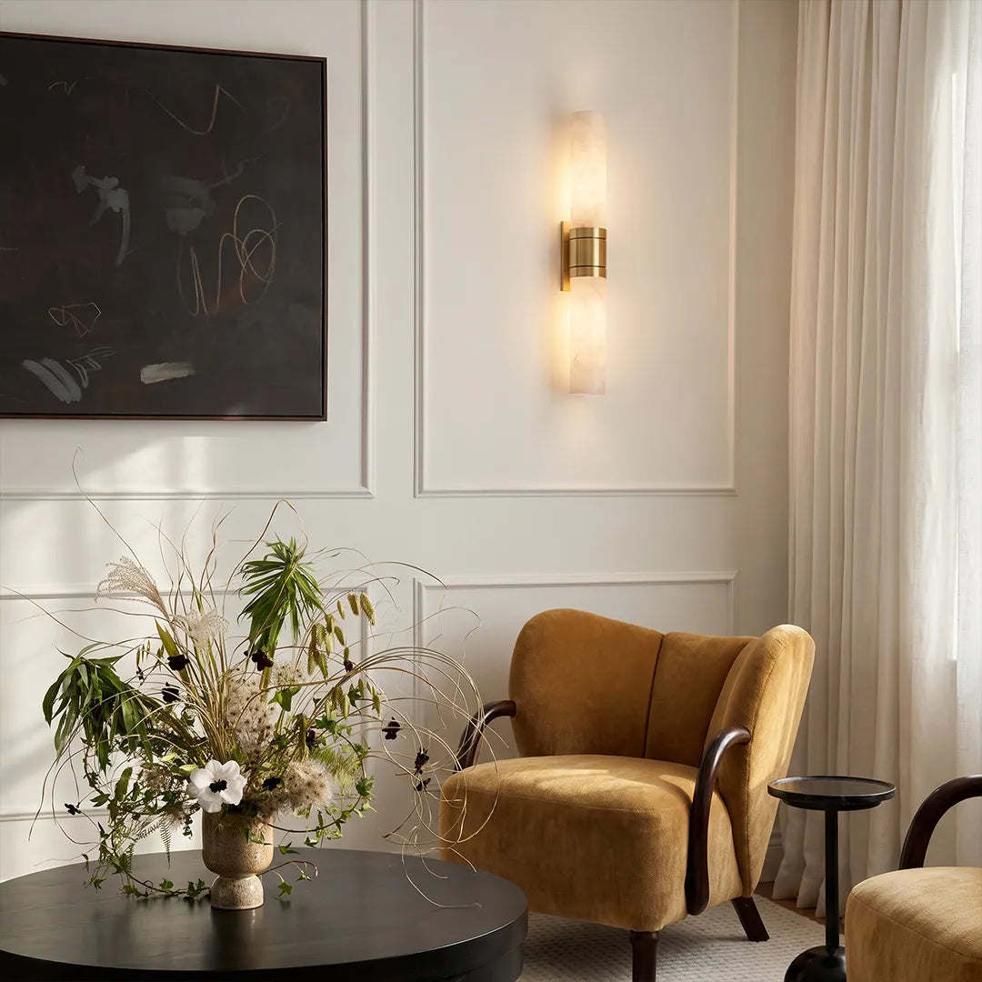 Niva marble wall sconce in a sitting area, casting a soft warm glow on the wall