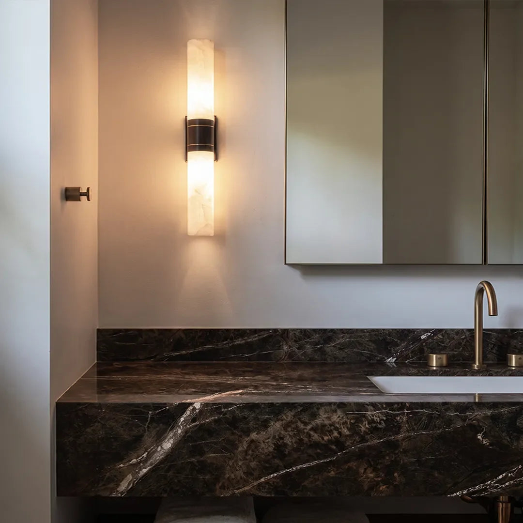 Niva marble wall sconce used as vanity lighting, gold finish with warm diffused glow