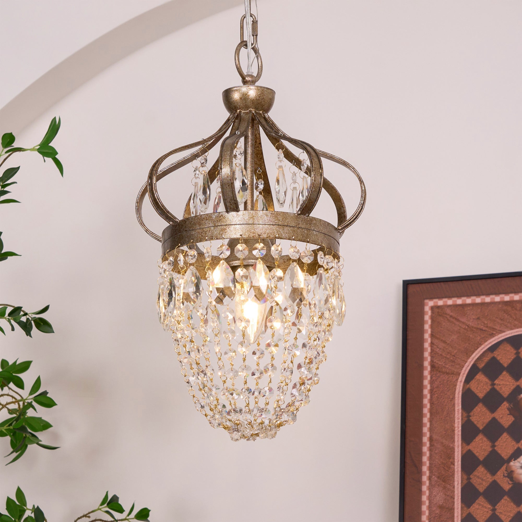 Crystal chandelier for dining room shown lit, warm light through glass teardrops