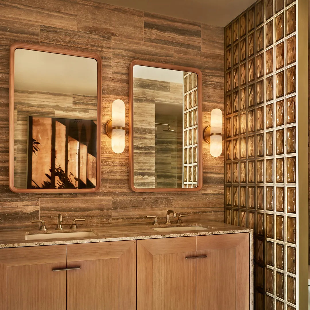 Niva dual-shade marble and brass wall sconce installed as bathroom vanity lighting