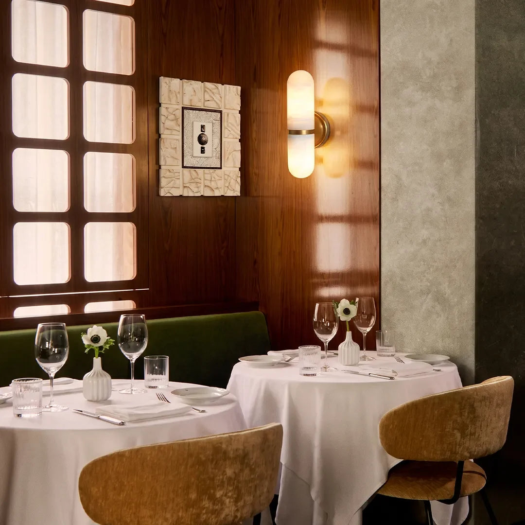 Niva brass and marble double wall sconce in a modern dining area