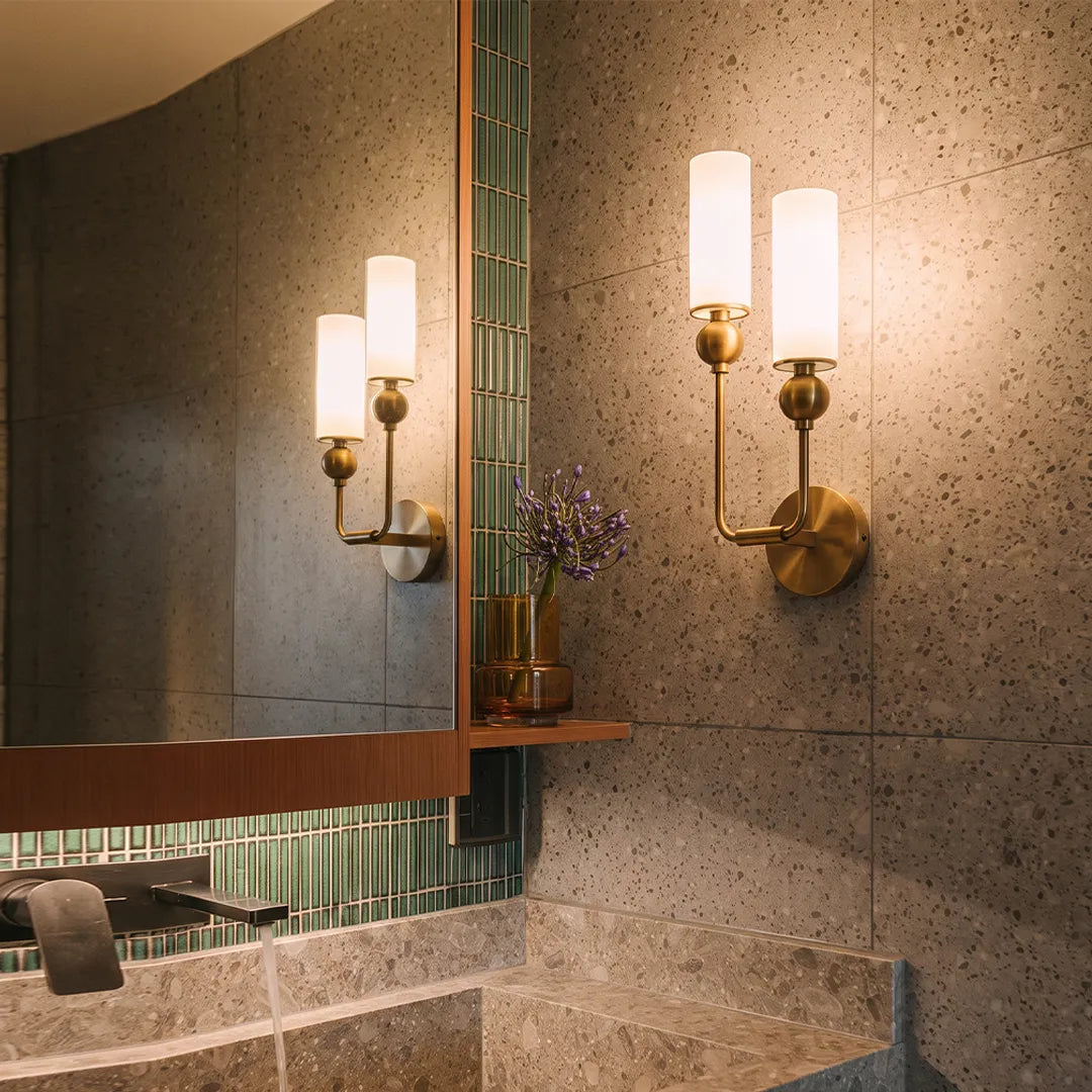 Niva brass and marble wall sconce mounted either side of a bathroom mirror
