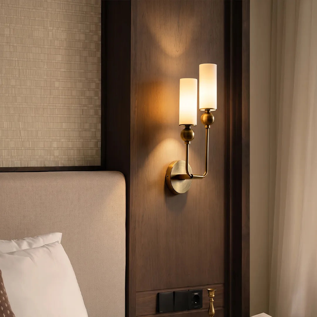 Niva double wall sconce on a bedroom feature wall, warm ambient glow through marble shades