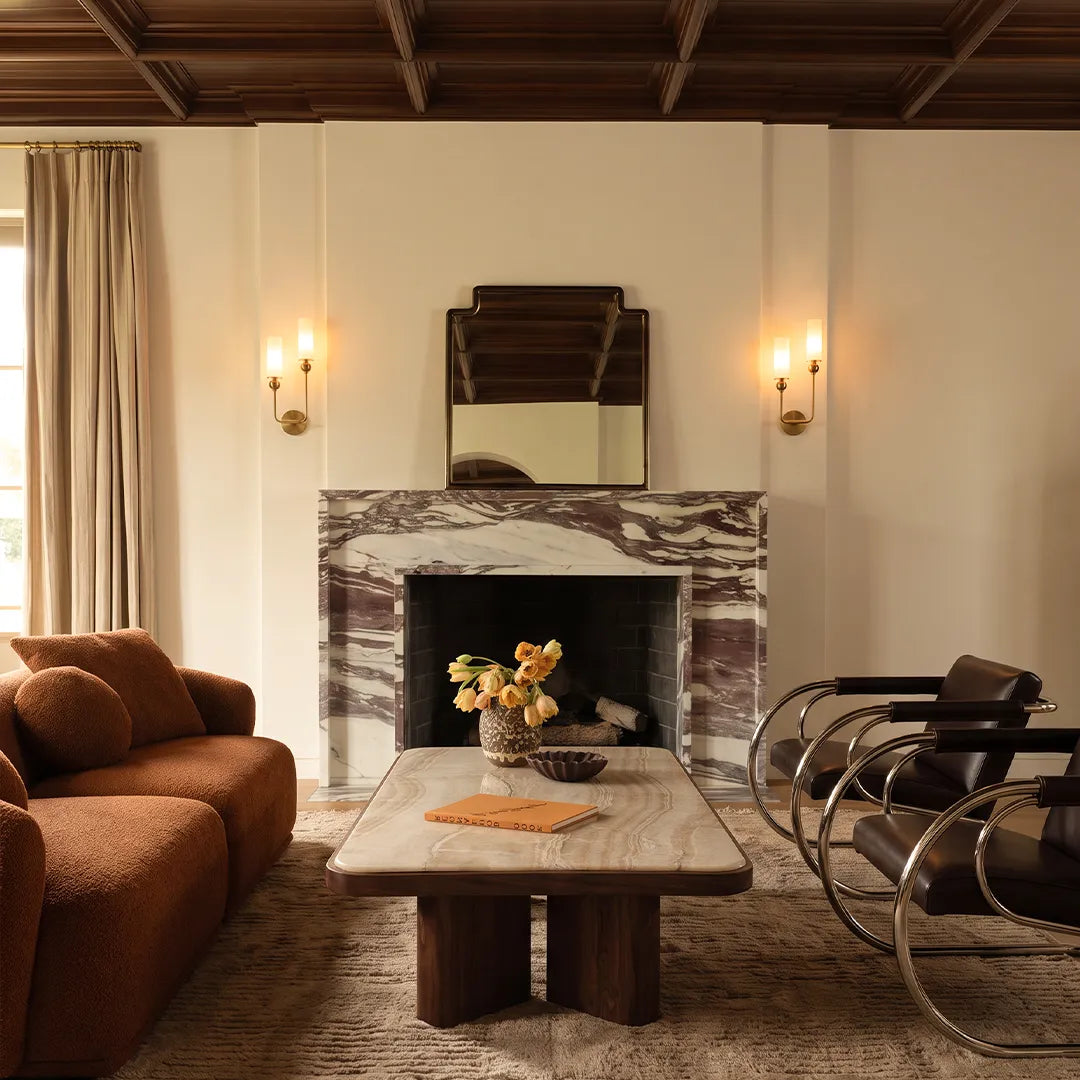 Niva double marble shade wall sconce above a fireplace in a modern interior