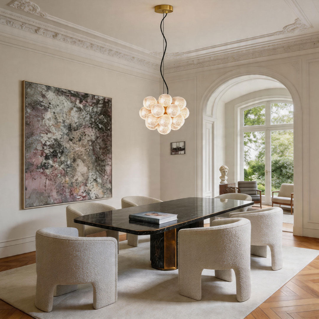 Auréline glass globe chandelier above a dining table, warm ambient light in a modern dining room