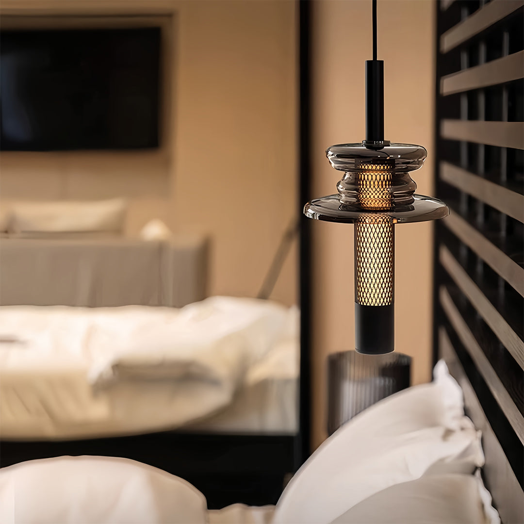 Aureon glass pendant light providing warm bedroom illumination above a bedside area
