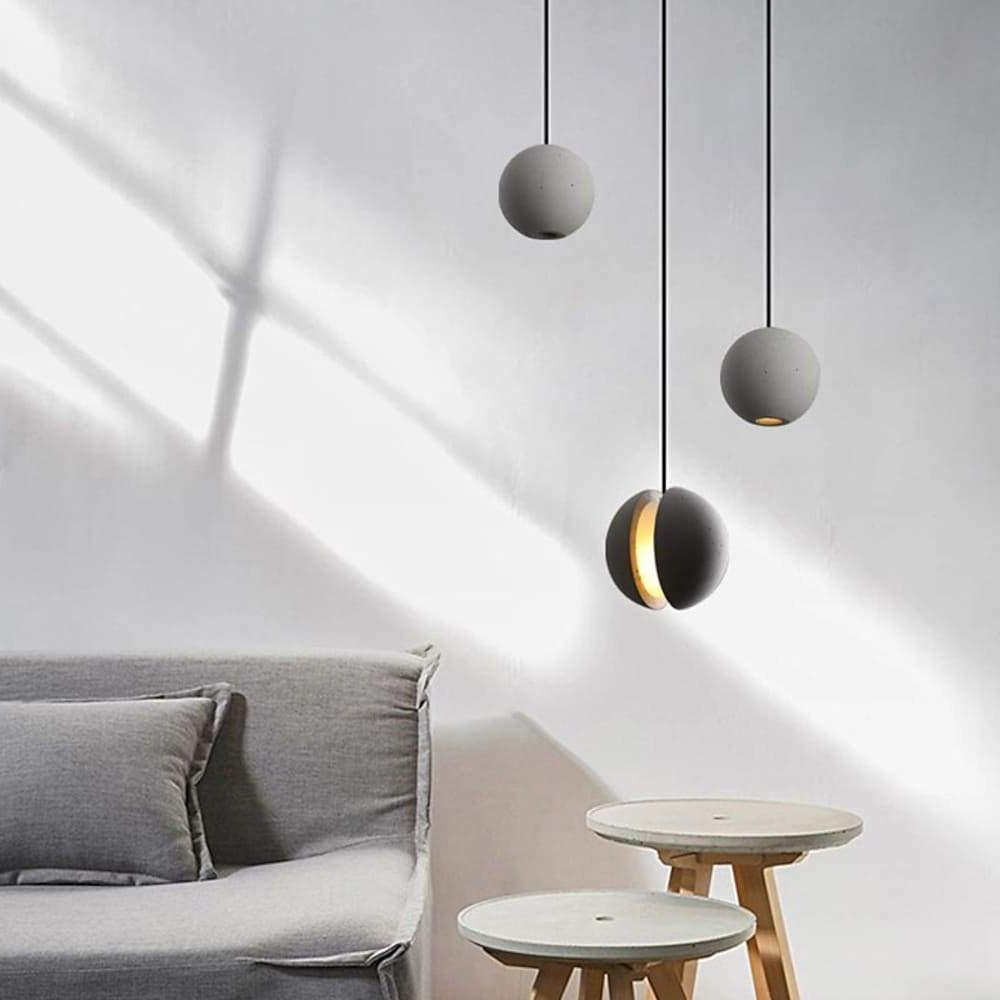 Aureon cement globe pendant light with warm 3000K glow in an evening dining room