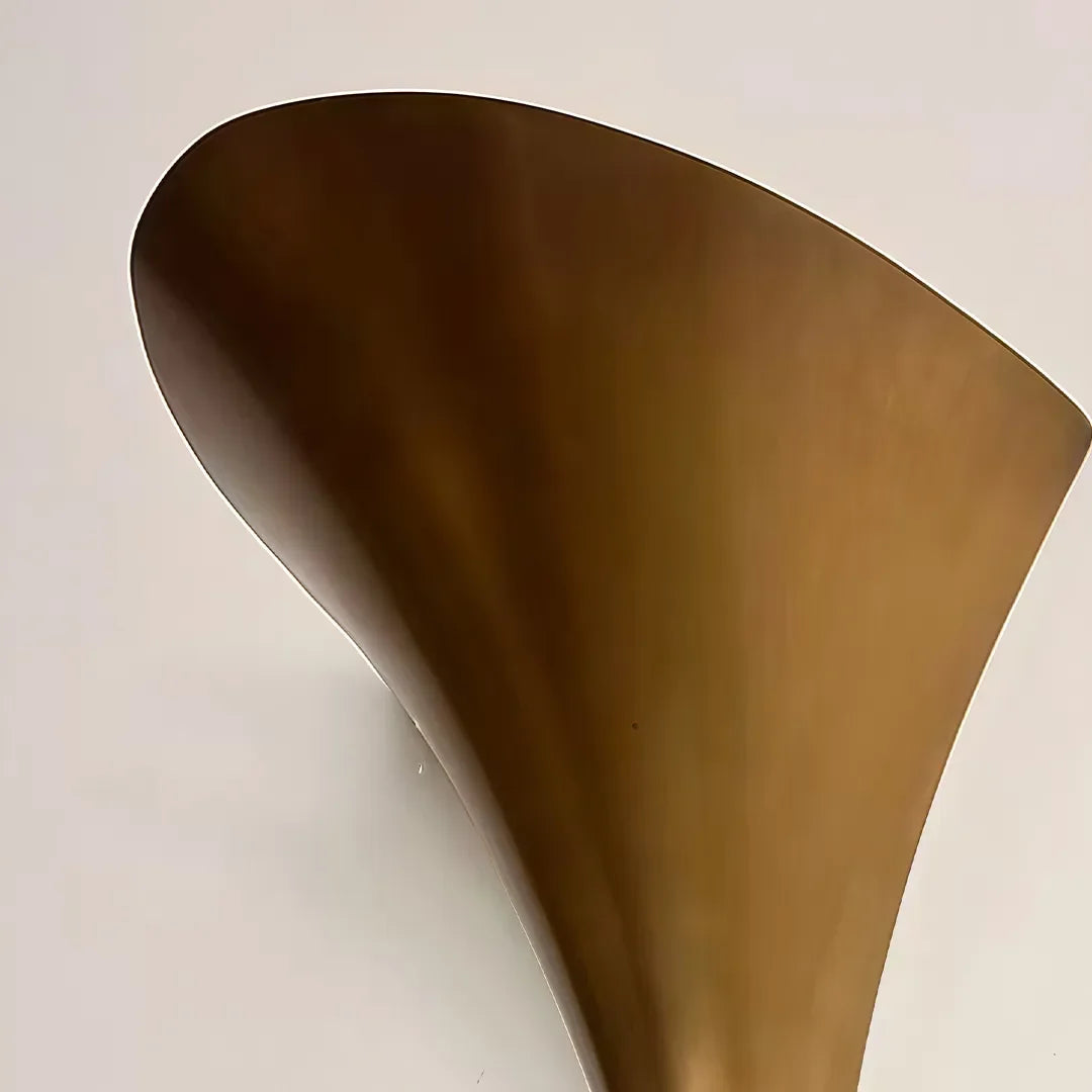 Close-up of the flared cone shade on the Niva sculptural brass wall sconce