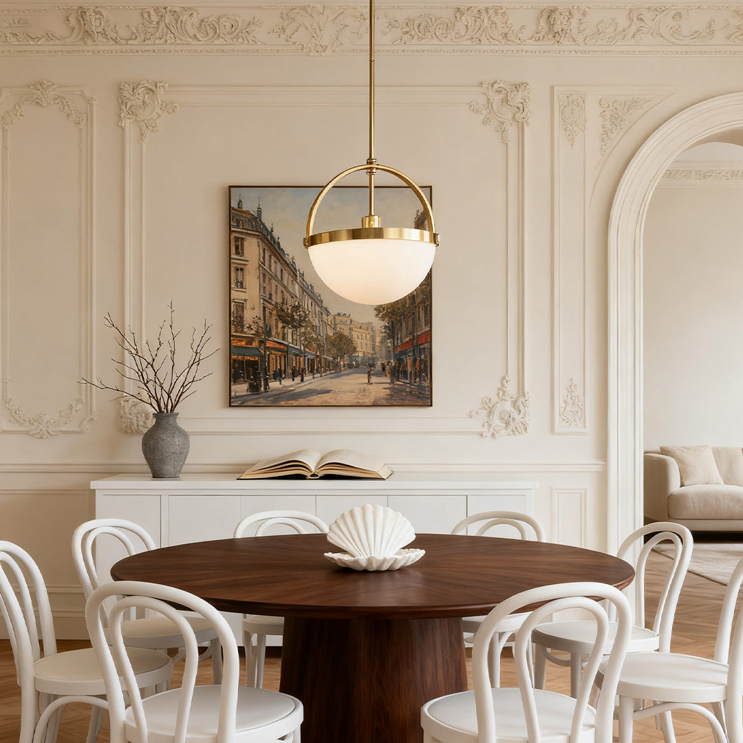 Gold and white frosted glass pendant light above a round wooden table in a modern interior