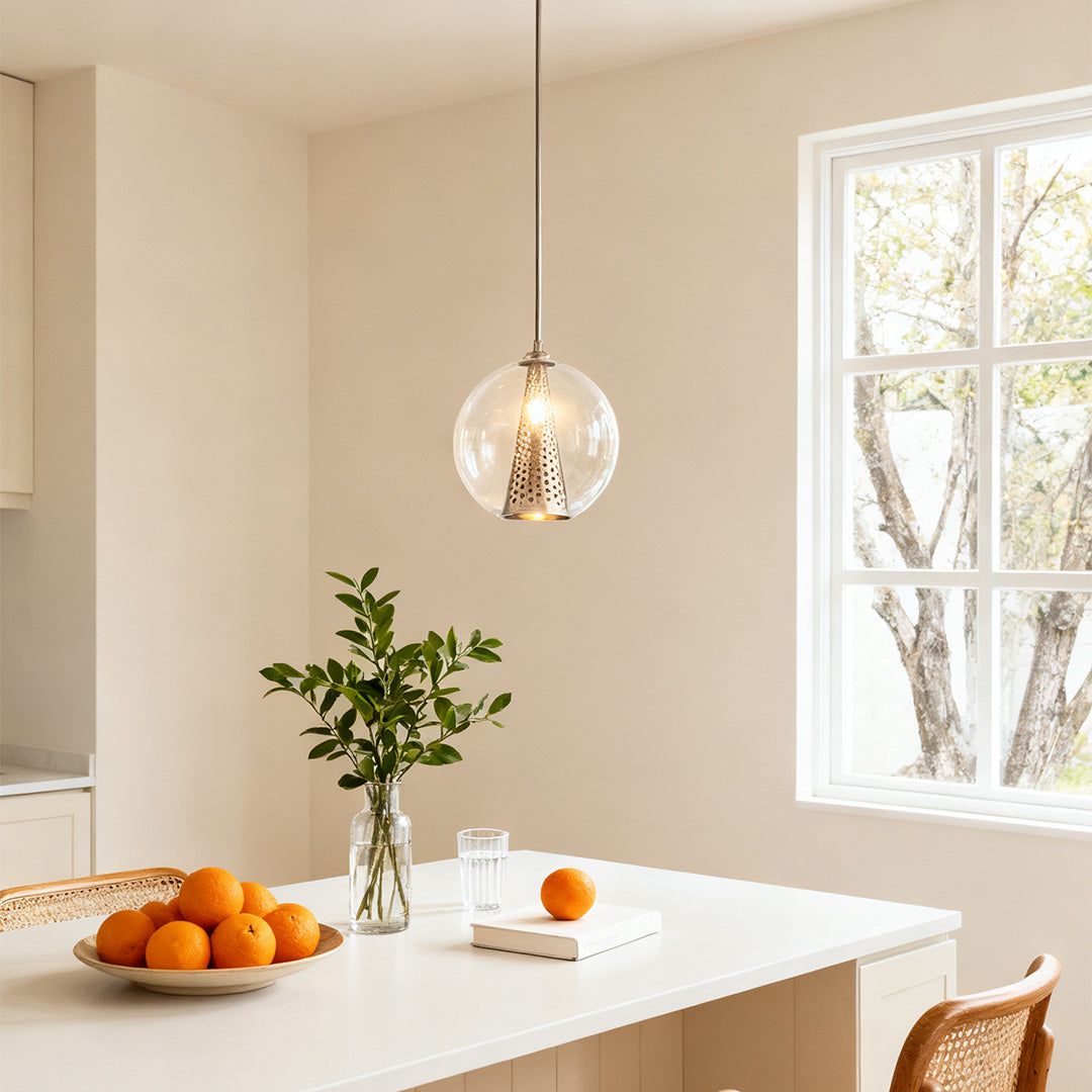 Aureon glass globe pendant light in a bright modern kitchen above a dining table