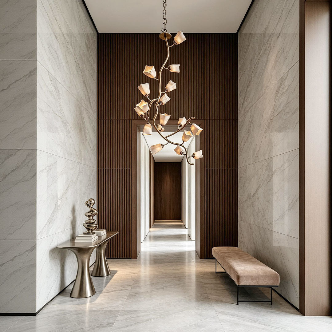 Glass and stainless steel chandelier suspended in a tall hallway interior