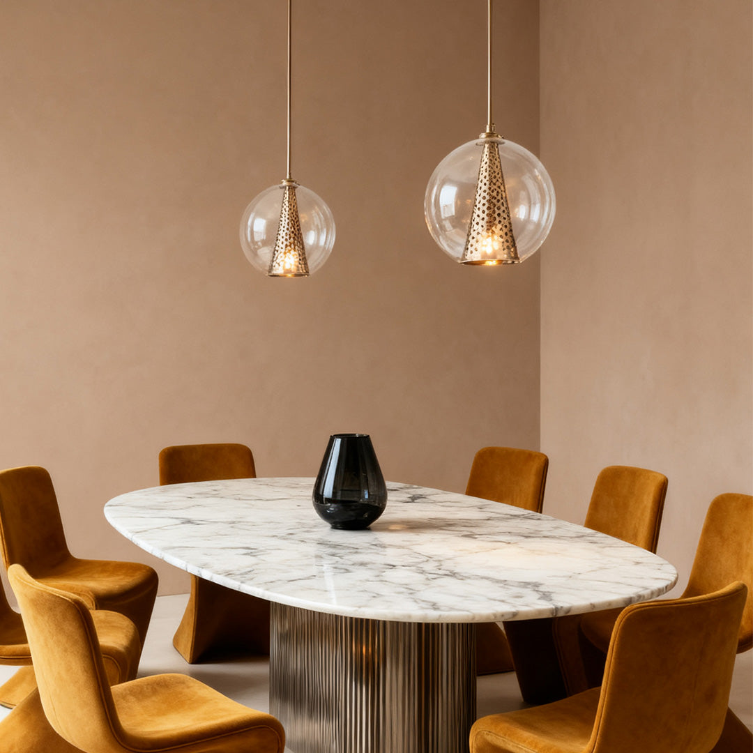 Pair of Aureon glass ball pendant lights above a taupe dining table with velvet chairs