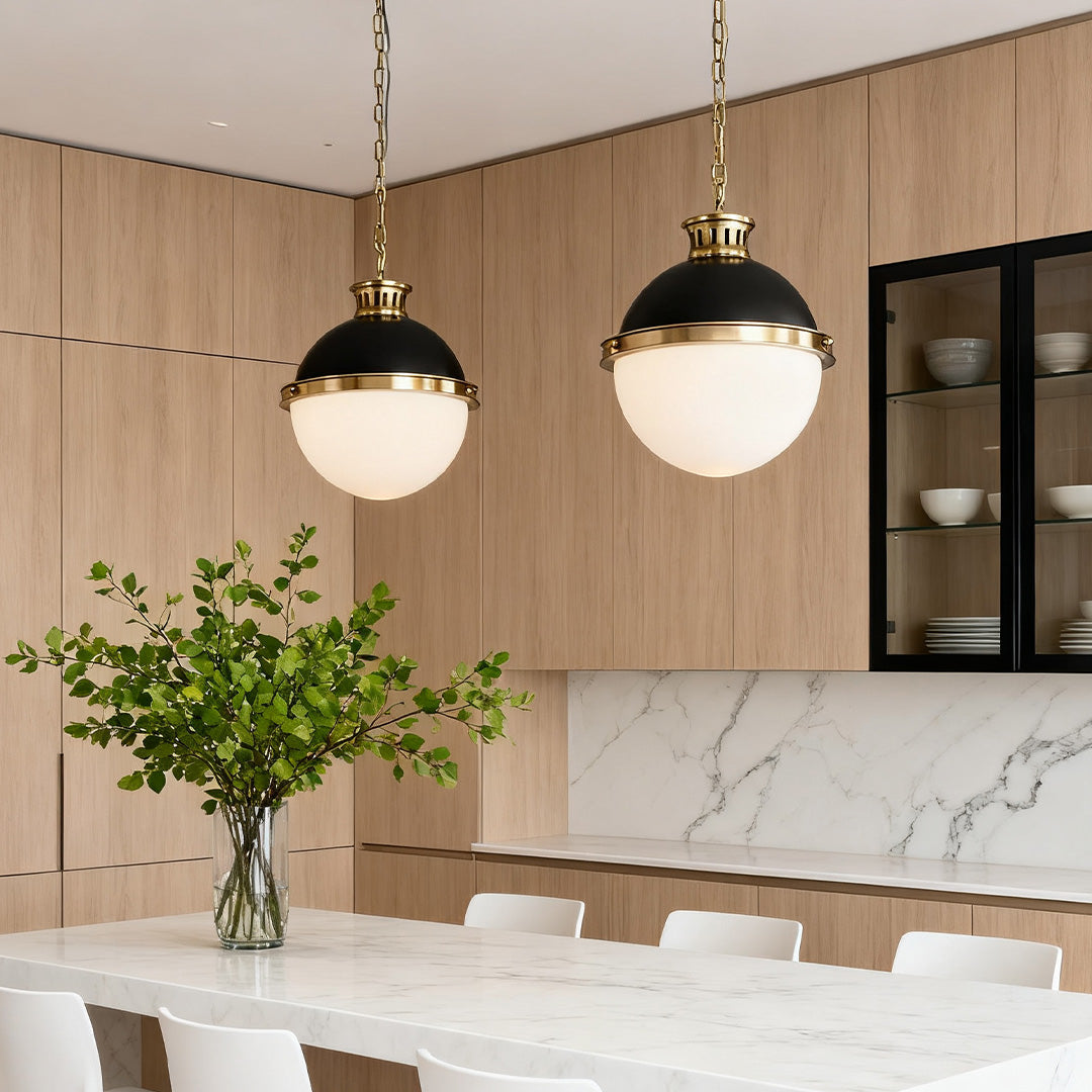 Pair of Aureon modern black and brass glass globe pendant lights over a kitchen counter