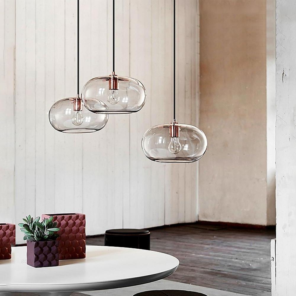 Aureon electroplated glass pendant light in transparent finish, shown lit above a kitchen island