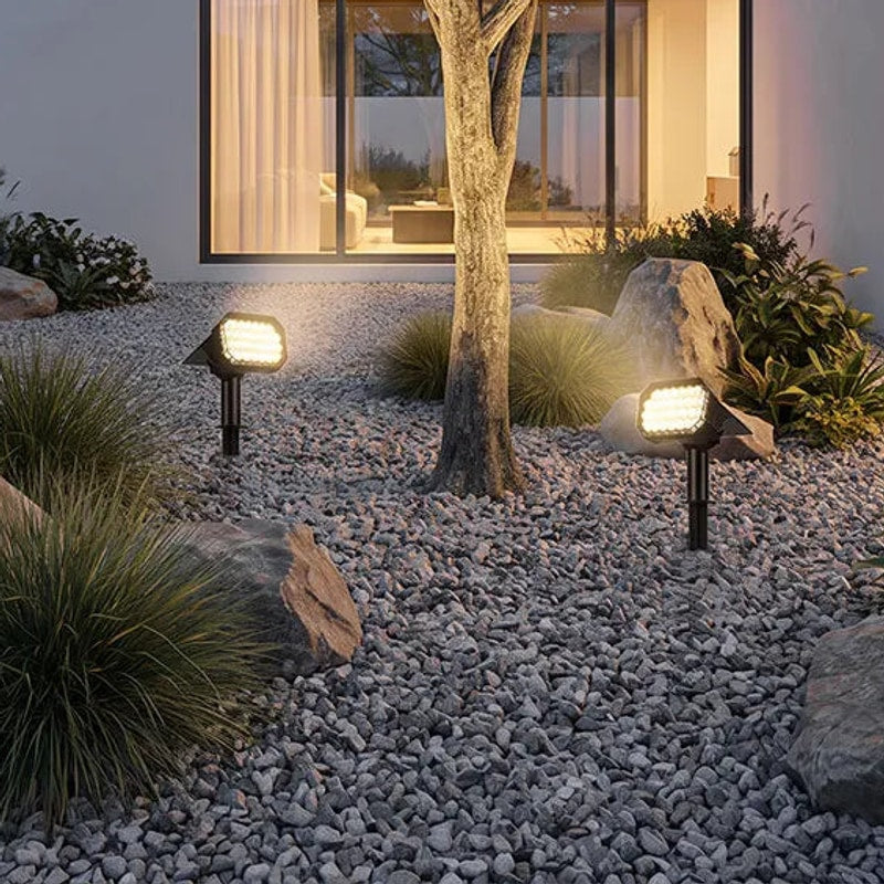 Multiple Solvara solar garden stake lights illuminating a pathway in a modern garden