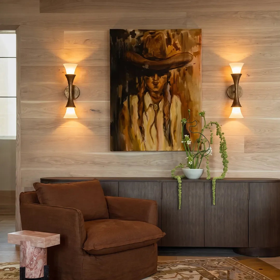 Pair of Niva brass wall sconces mounted in a modern living room