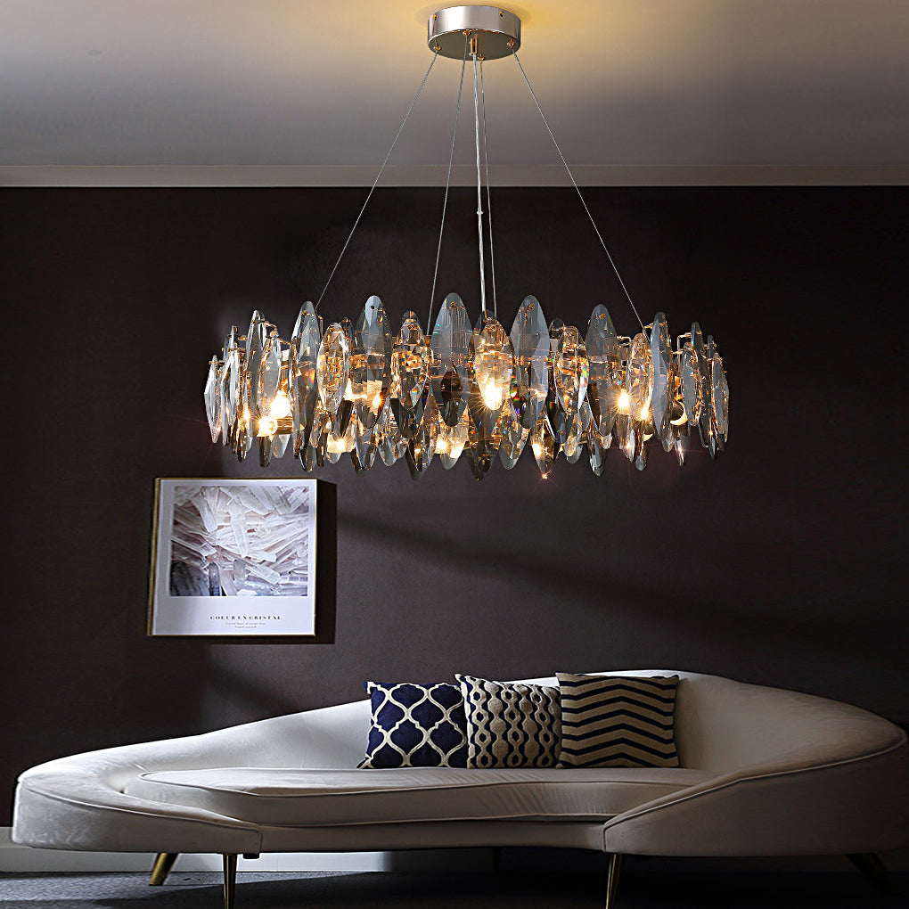 Round crystal chandelier casting warm ambient glow in a dark modern interior