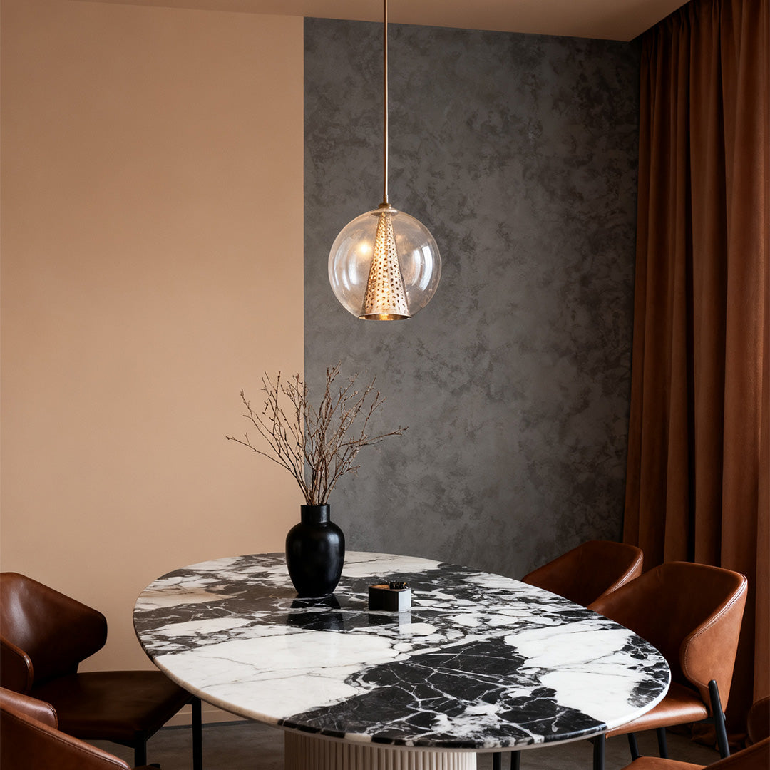 Single Aureon brass-finish glass pendant light above a marble surface in a contemporary interior