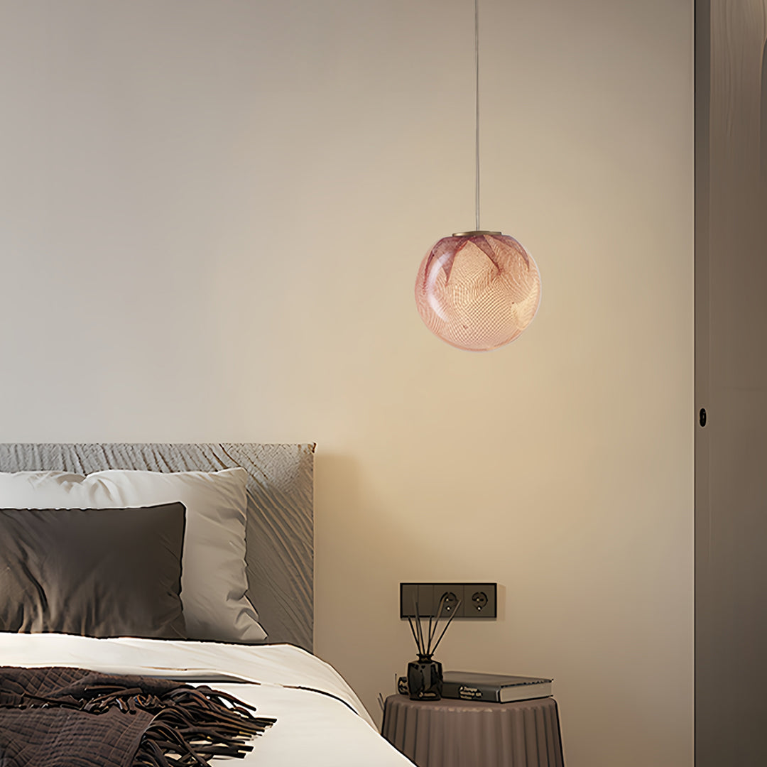 Set of textured amber glass globe pendant lights above a bedroom space
