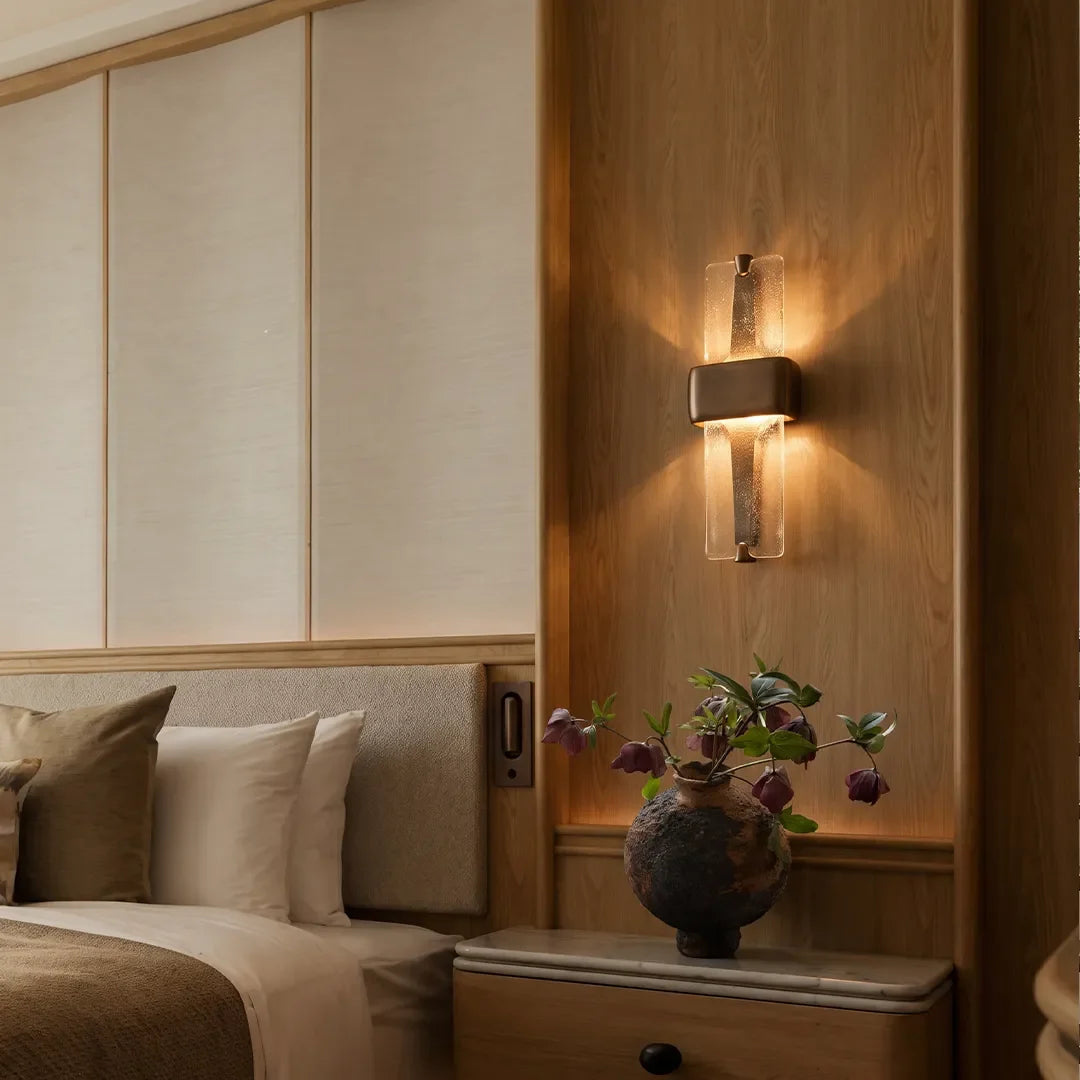 Niva wall sconce on a wood accent wall, warm ambient glow, modern interior