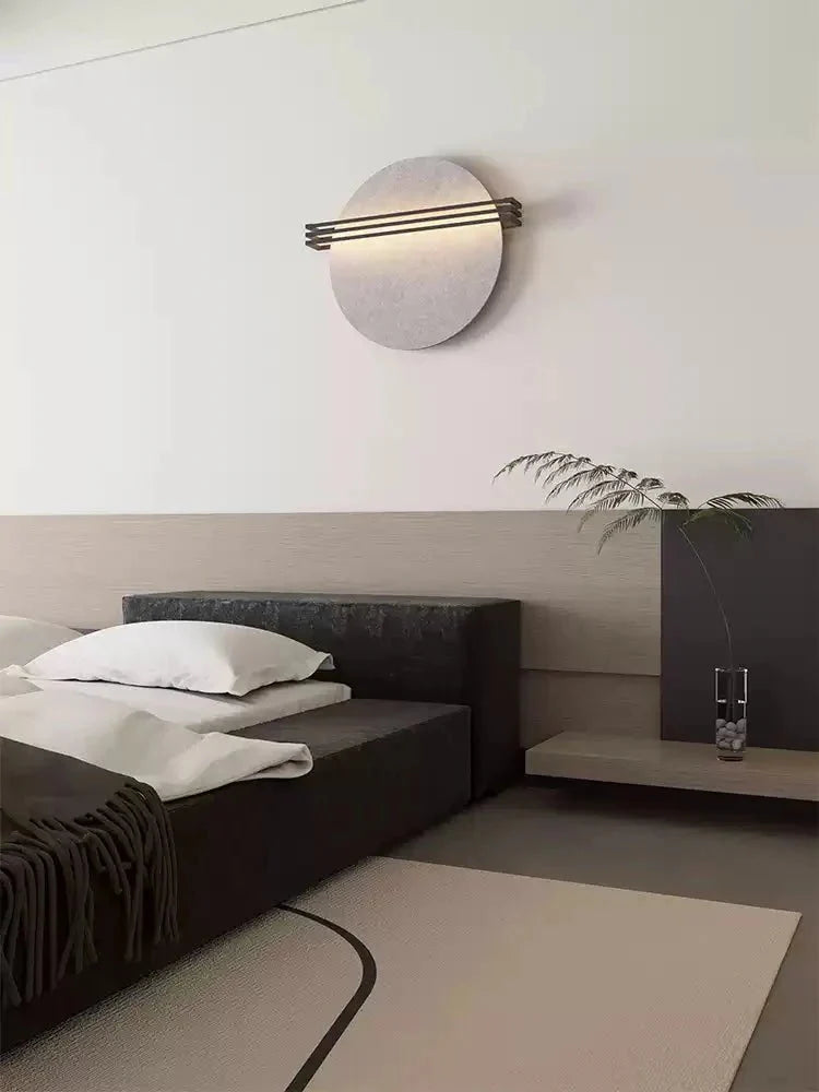 Side profile of the Vantara circular felt wall sconce showing depth and cord detail