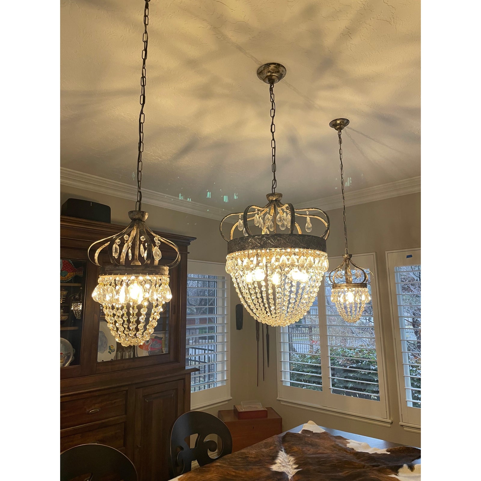 Vantara chandelier lit overhead in a dining room, prismatic glass crystal light
