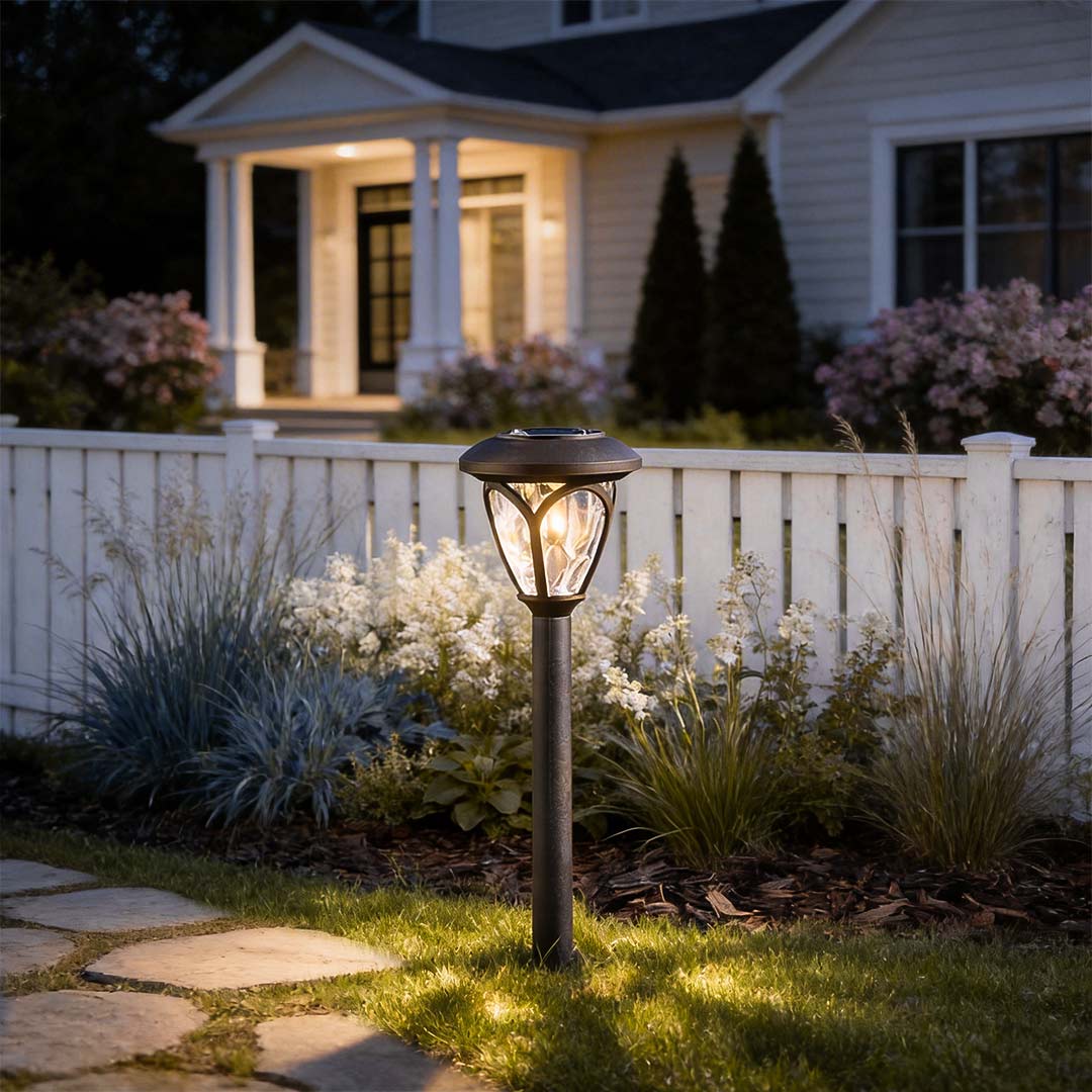 Solvara solar garden stake light with frosted glass lampshade in matte black finish on a garden path at dusk