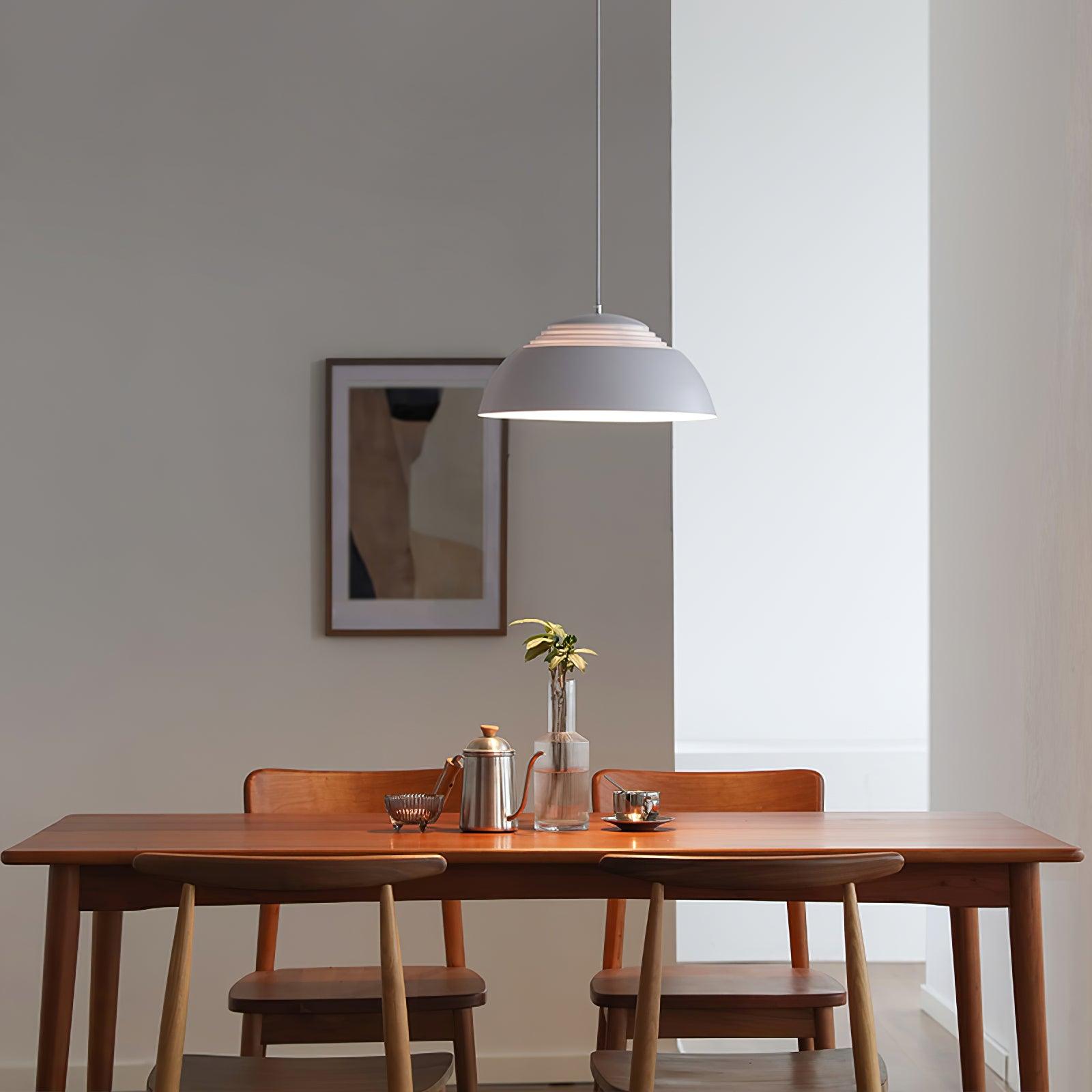Vantara pendant light in matte white casting soft downward light over a dining table