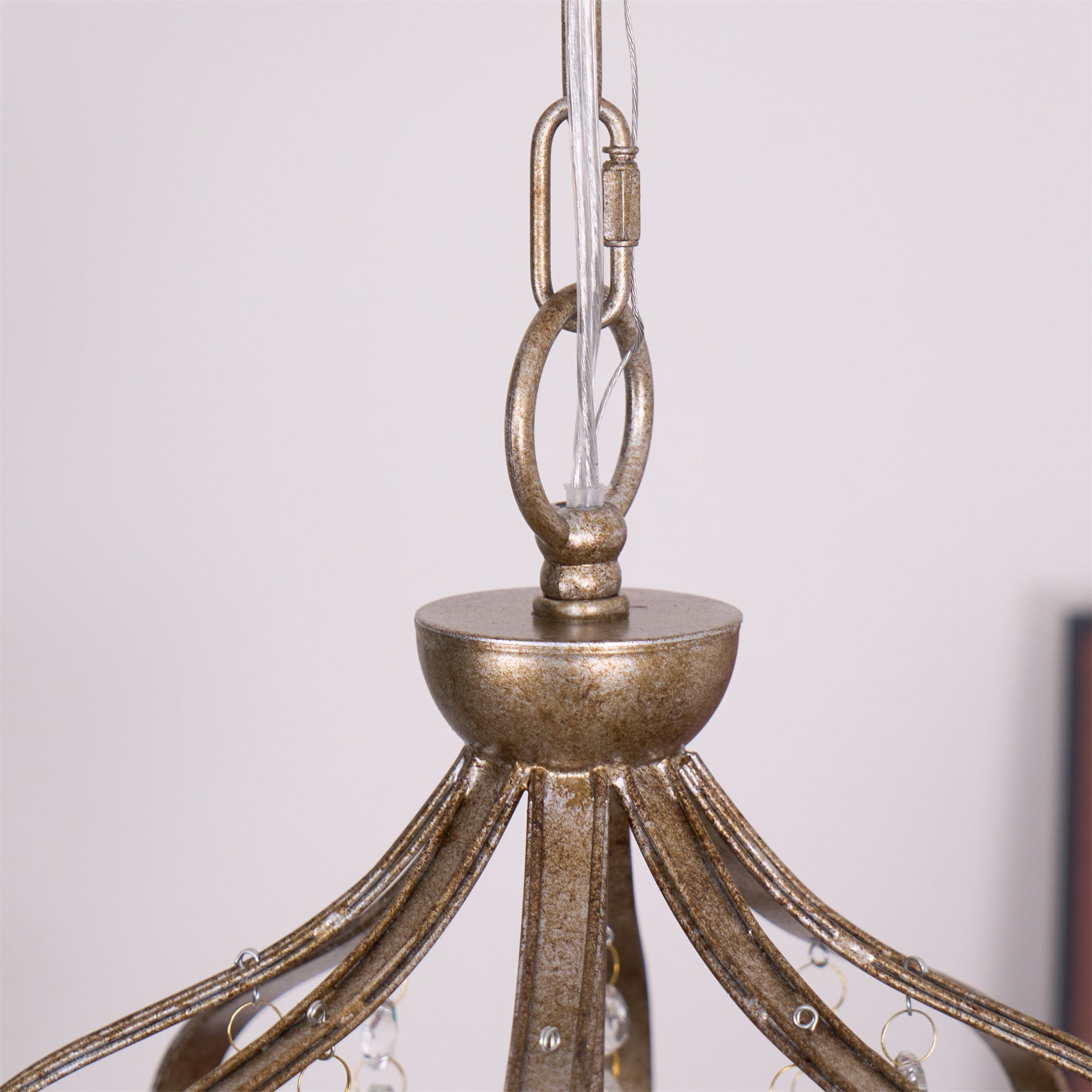 Vantara crystal chandelier antique gold lit at evening, warm light through glass