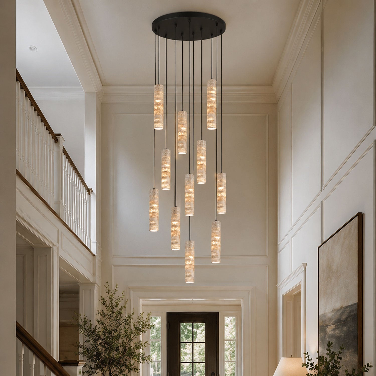 Two travertine cylinder pendant lights hanging at different heights above a kitchen counter