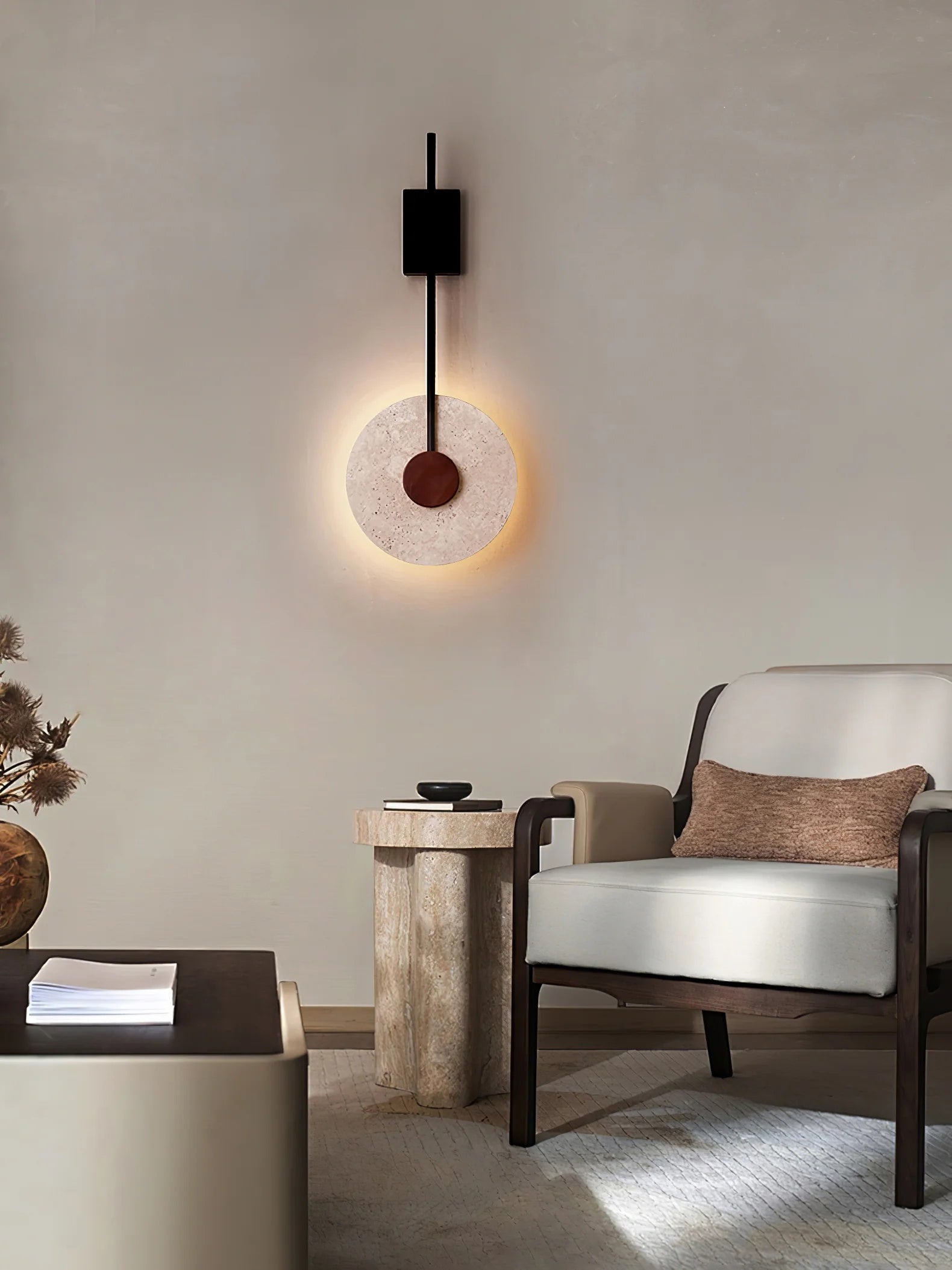 Tovi travertine disc wall light beside a bed used as a bedside reading light