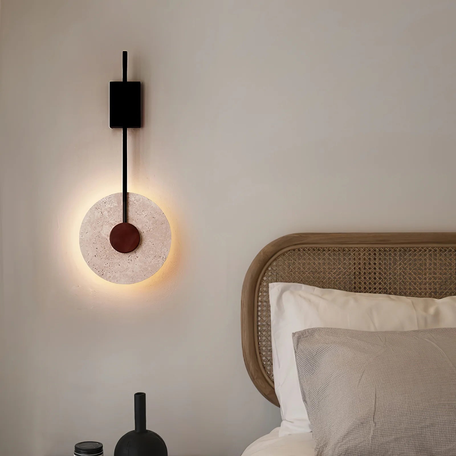 Tovi stone wall light casting a soft warm glow in a Japandi living room