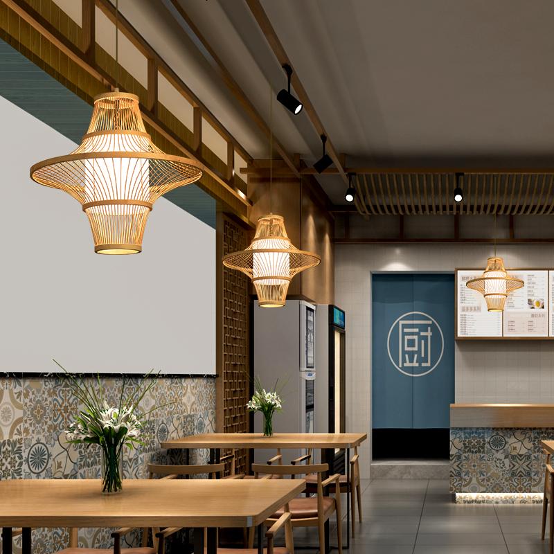 Woven bamboo pendant light hanging above a dining table, showing natural cone shade detail
