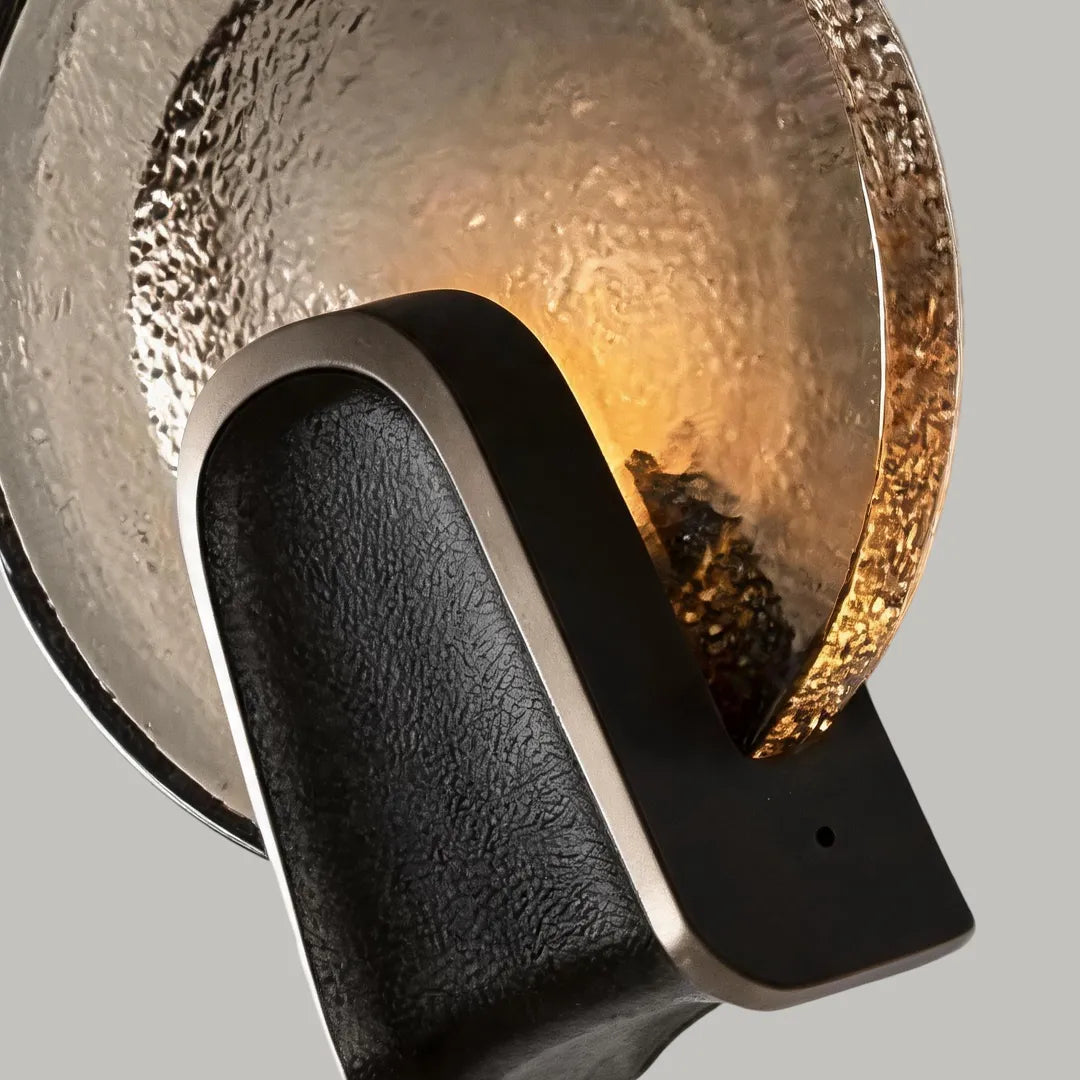 Close-up of black smoked glass round wall sconce, solid brass body and rippled glass shade