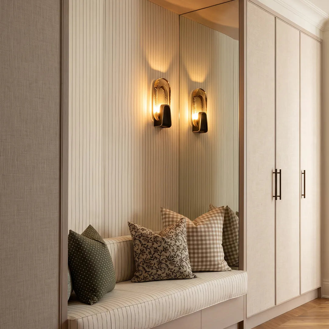 Oval glass wall sconce above a built-in bench in a contemporary interior, brass wall light