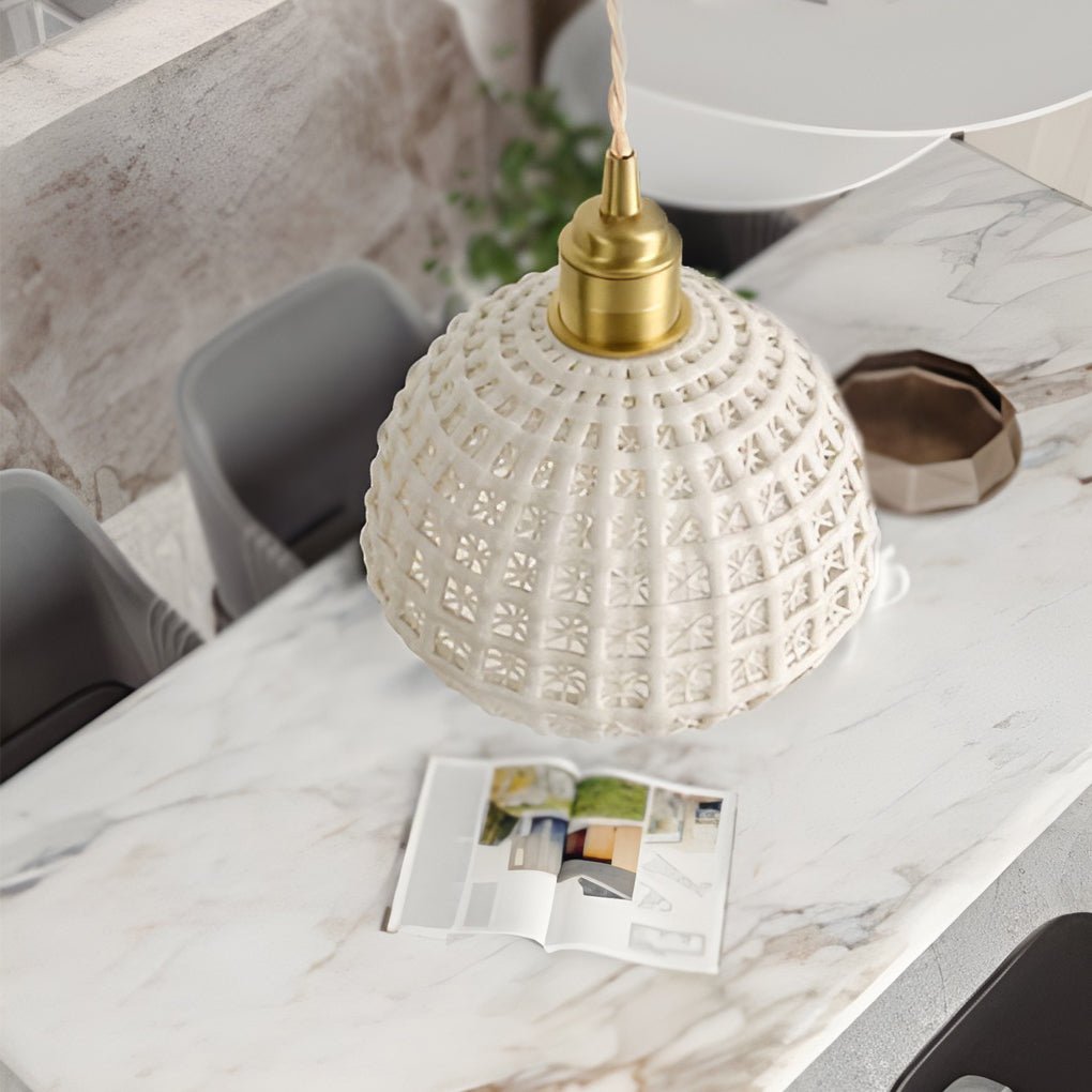Aureon semi-globe ceramic pendant light in pink, lit, showing warm downward glow in an entryway
