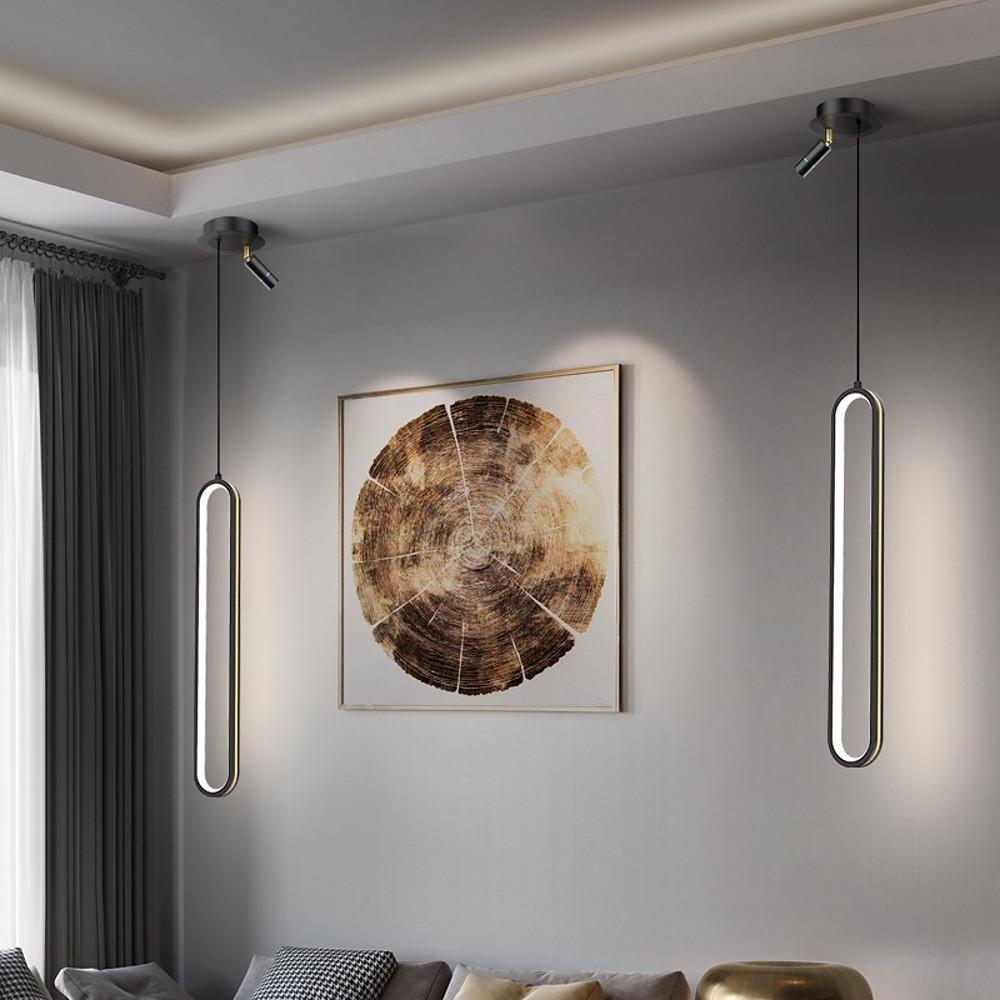 Aureon elongated metal lantern pendant light in black, hanging above a kitchen island in a modern interior