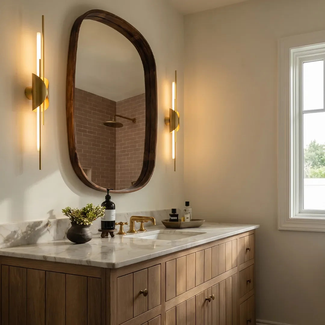 Niva brass wall sconce used as bathroom vanity lighting beside a mirror