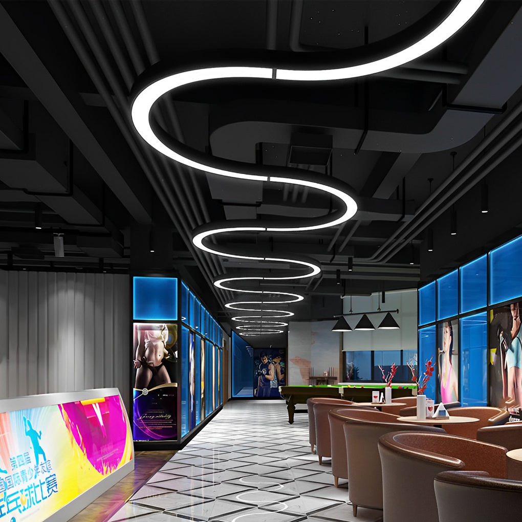 Aureon C-shape LED pendant lights installed along a commercial corridor ceiling in a modern interior