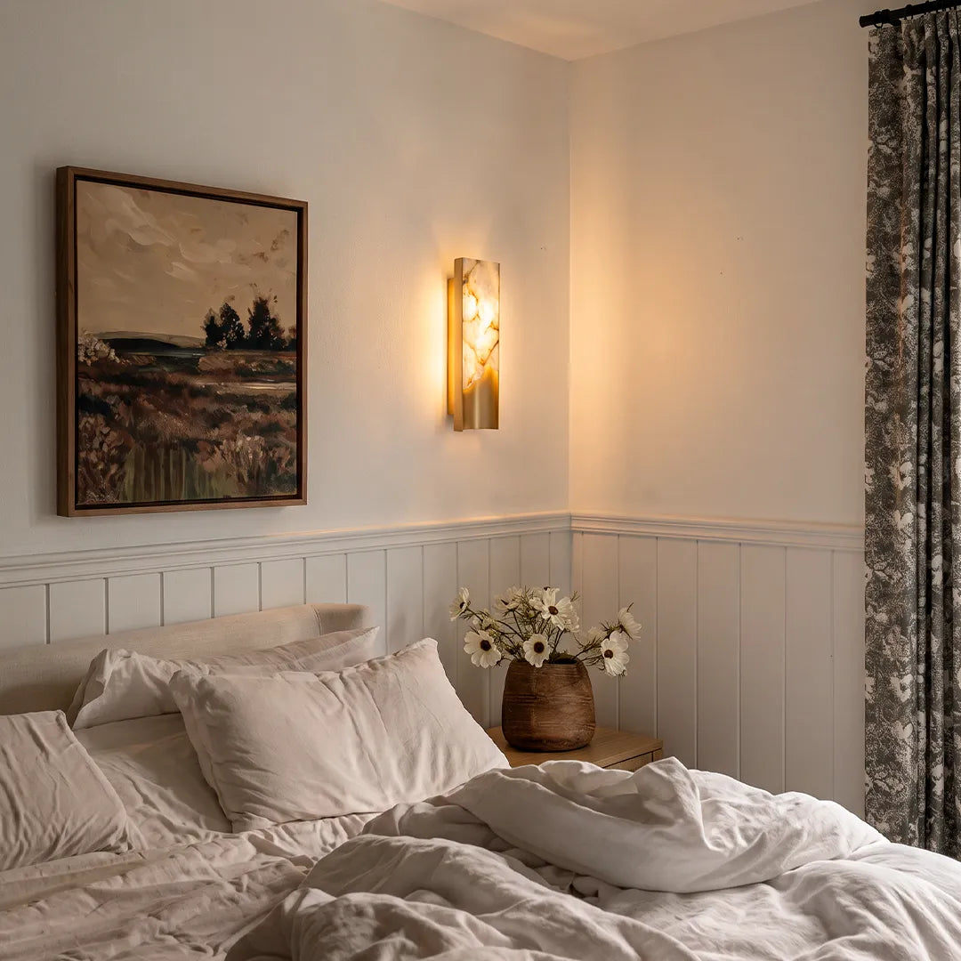 Niva marble wall sconce installed beside a bed in a modern bedroom interior